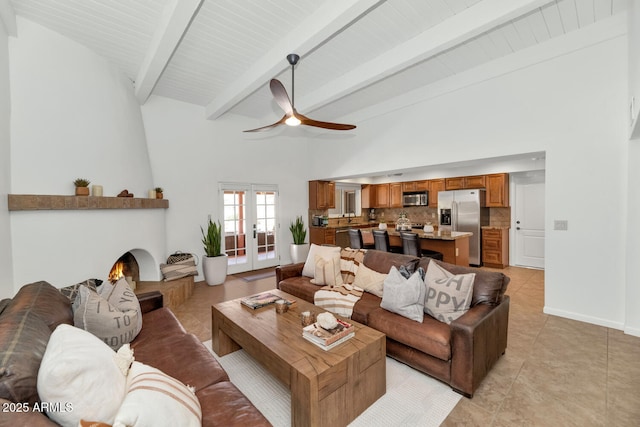 12682 N 80th Pl, Scottsdale, AZ 85260 - living room with a ceiling fan, beamed ceiling, light tile patterned flooring, a fireplace, and high vaulted ceiling
