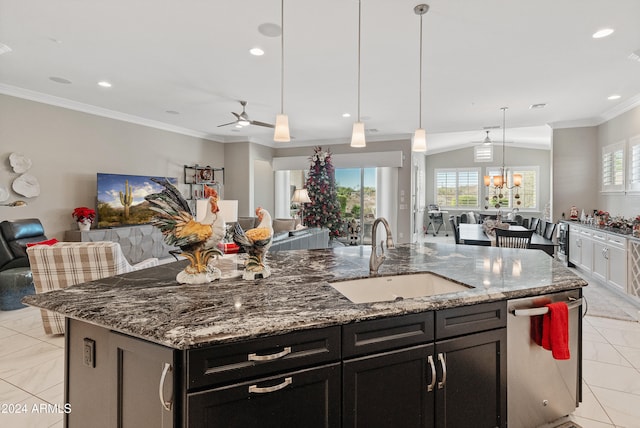 kitchen with sink, an island with sink, pendant lighting, stone countertops, and ceiling fan with notable chandelier