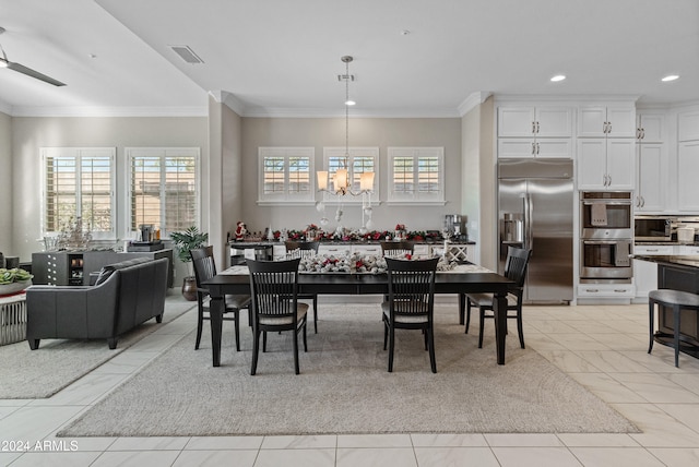 dining room featuring ceiling fan with notable chandelier and ornamental molding