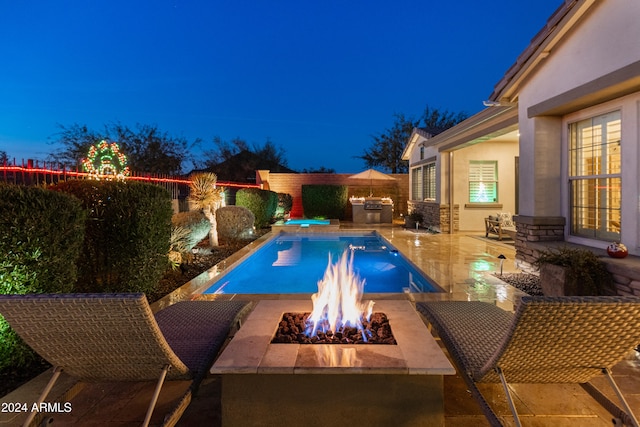 view of pool with a patio area, exterior kitchen, and a fire pit