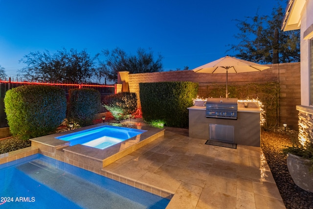 pool at dusk featuring an outdoor kitchen, a grill, and an in ground hot tub