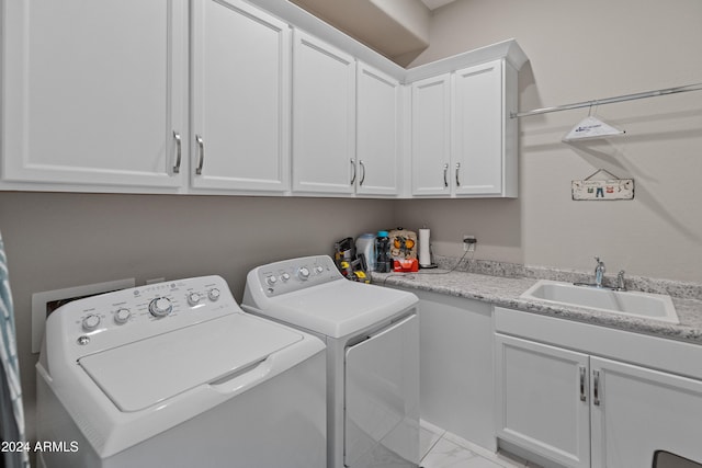 laundry room with cabinets, sink, and washing machine and dryer