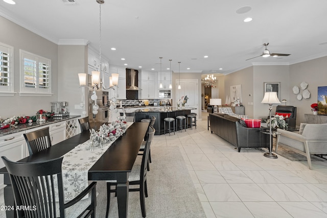 tiled dining room featuring ceiling fan with notable chandelier and ornamental molding