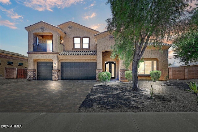 18207 W Sells Dr, Goodyear, AZ 85395 - mediterranean / spanish-style house with a garage, stucco siding, a balcony, a tiled roof, and decorative driveway