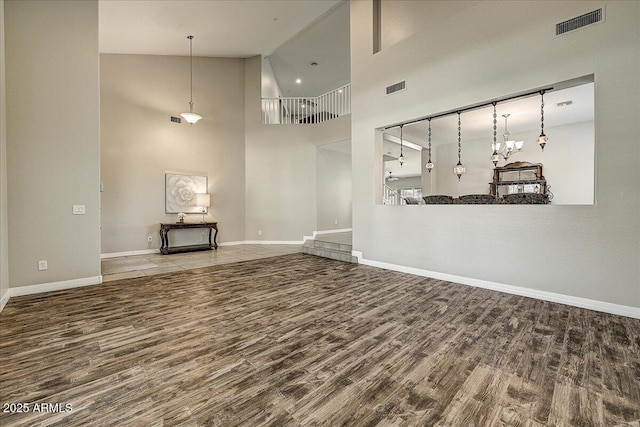 18207 W Sells Dr, Goodyear, AZ 85395 - unfurnished living room featuring wood finished floors and a towering ceiling