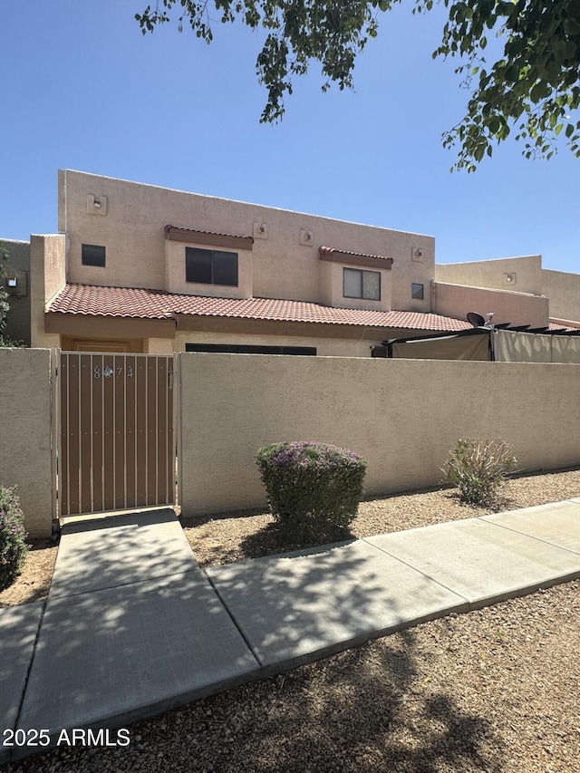 8874 N 48th Ln, Glendale, AZ 85302 - pueblo-style house featuring stucco siding, fence, and a gate