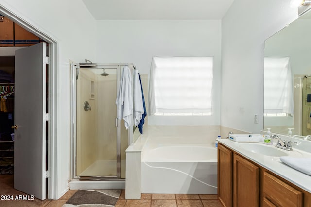 bathroom with vanity, tile patterned flooring, and plus walk in shower