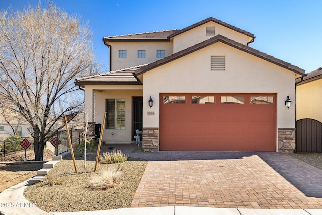 view of front of home featuring stone siding, a gate, decorative driveway, and stucco siding