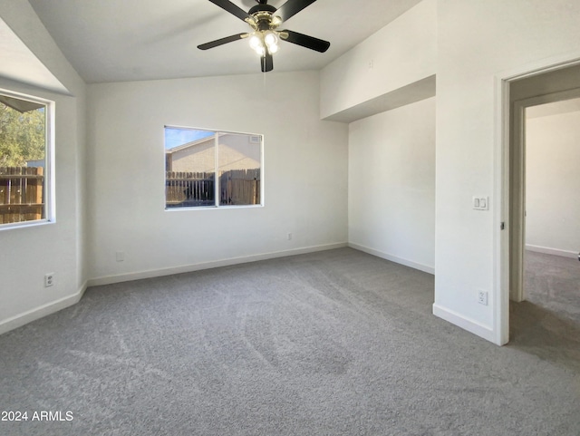 spare room featuring carpet, a wealth of natural light, ceiling fan, and lofted ceiling