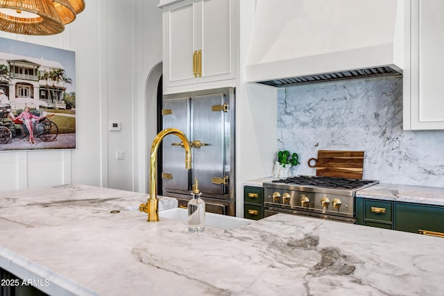 2339 E Virgo Pl, Chandler, AZ 85249 - kitchen with custom exhaust hood, stove, decorative backsplash, arched walkways, and a sink