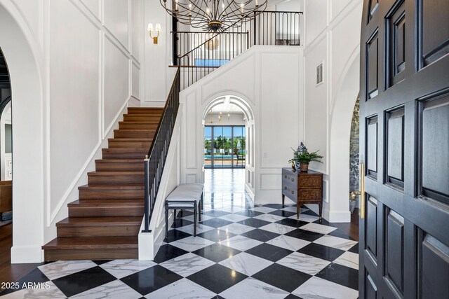 2339 E Virgo Pl, Chandler, AZ 85249 - foyer entrance with a decorative wall, arched walkways, a chandelier, a high ceiling, and stairway