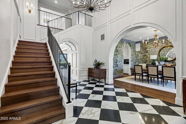 2339 E Virgo Pl, Chandler, AZ 85249 - stairs featuring a chandelier, a decorative wall, arched walkways, a towering ceiling, and healthy amount of natural light
