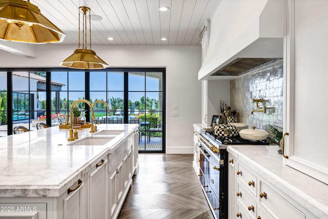 2339 E Virgo Pl, Chandler, AZ 85249 - kitchen with a sink, range with two ovens, wall chimney range hood, recessed lighting, and white cabinetry