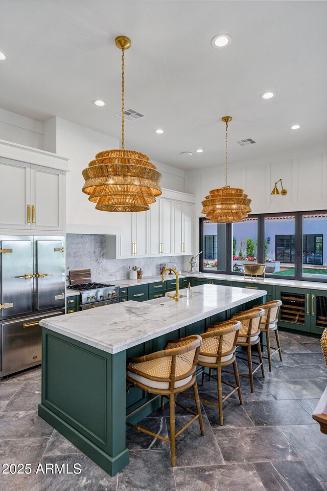 2339 E Virgo Pl, Chandler, AZ 85249 - kitchen featuring green cabinets, a center island with sink, range with gas cooktop, white cabinets, and stainless steel built in fridge