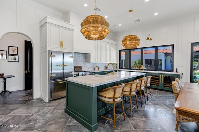 2339 E Virgo Pl, Chandler, AZ 85249 - kitchen with built in refrigerator, a chandelier, recessed lighting, a center island with sink, and white cabinetry