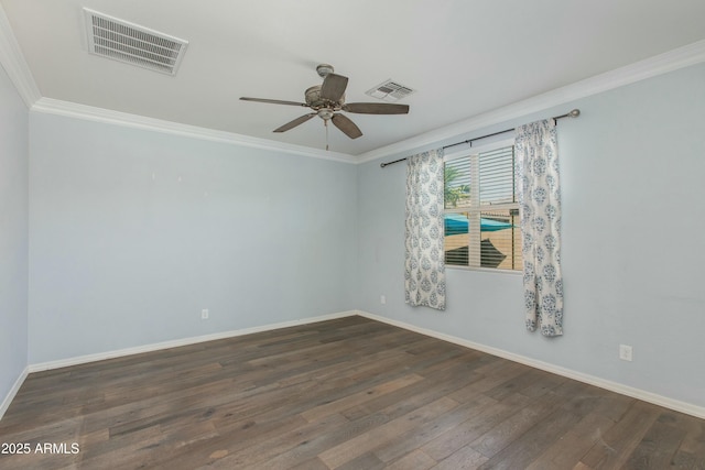 empty room with ornamental molding, visible vents, baseboards, and dark wood-style floors