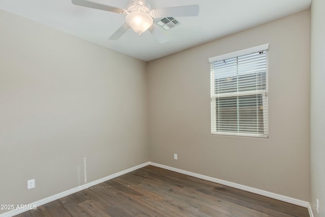 empty room featuring dark wood-style floors, baseboards, visible vents, and a ceiling fan