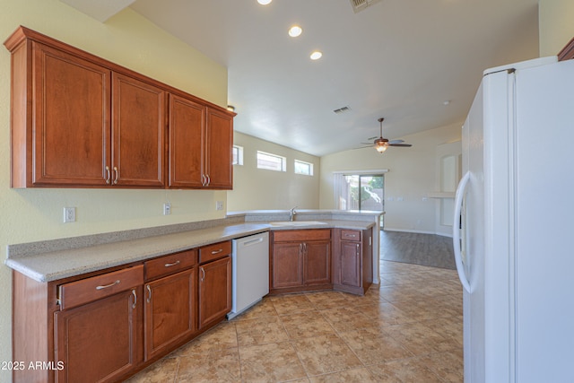 kitchen featuring ceiling fan, lofted ceiling, kitchen peninsula, sink, and white appliances