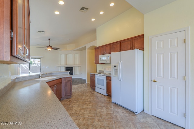 kitchen featuring ceiling fan, sink, and white appliances