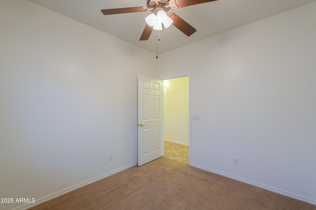 spare room with ceiling fan and light carpet