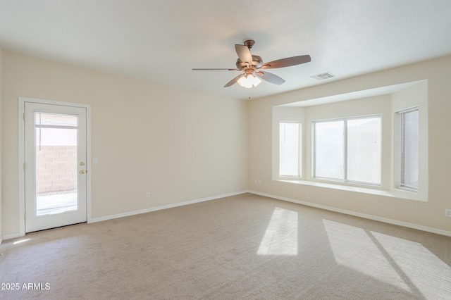 carpeted spare room featuring ceiling fan