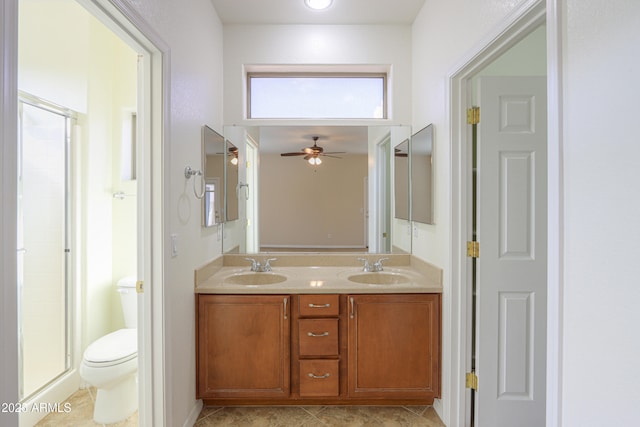 bathroom featuring toilet, ceiling fan, tile patterned floors, an enclosed shower, and vanity