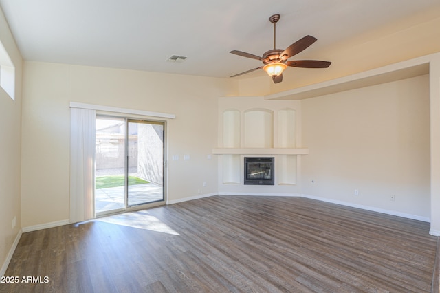 unfurnished living room with ceiling fan and dark wood-type flooring