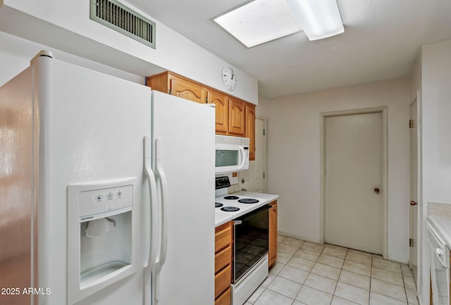 kitchen with white appliances and light tile patterned floors