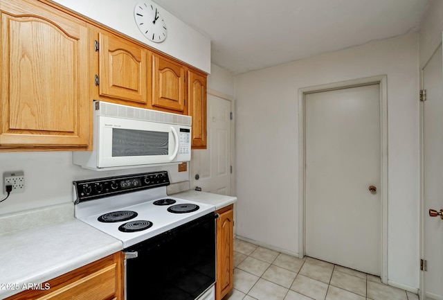 kitchen featuring light tile patterned flooring and white appliances