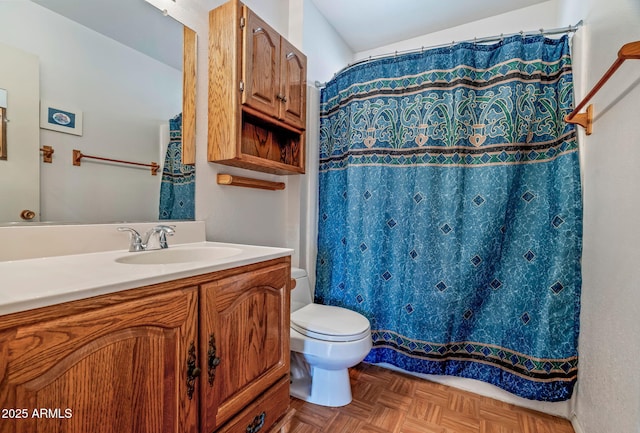 bathroom with vanity, toilet, and parquet floors