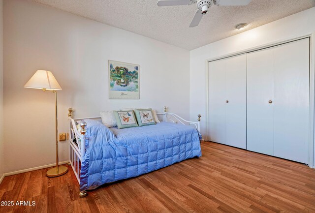 bedroom featuring ceiling fan, a closet, light hardwood / wood-style floors, and a textured ceiling