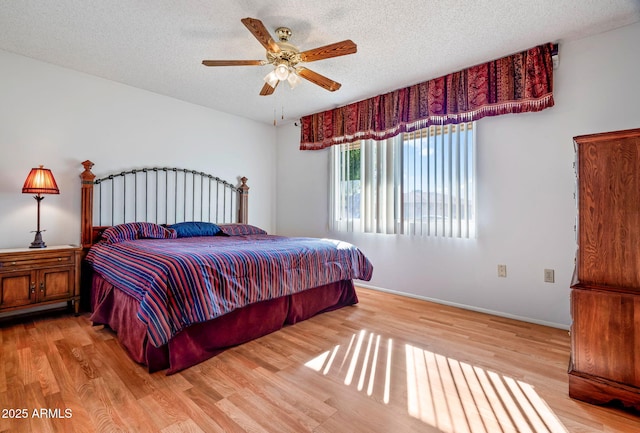 bedroom with ceiling fan, a textured ceiling, and light wood-type flooring