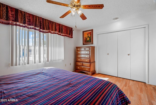 unfurnished bedroom featuring ceiling fan, light hardwood / wood-style floors, a textured ceiling, and a closet