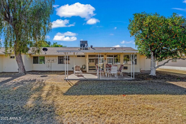 rear view of property featuring a patio area and a yard