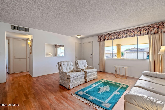 living room with hardwood / wood-style flooring, plenty of natural light, and a textured ceiling