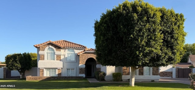 view of front facade with stone siding, stucco siding, and a front yard