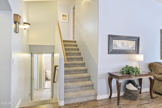 staircase with wood finished floors and baseboards