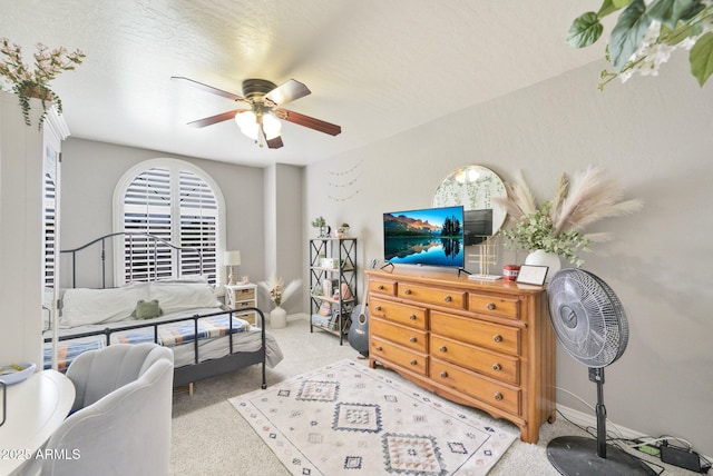 carpeted bedroom with a ceiling fan and baseboards