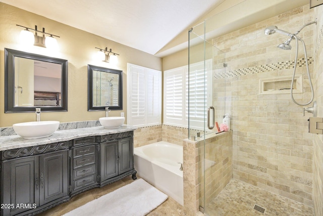 bathroom with vaulted ceiling, a bath, a stall shower, tile patterned flooring, and double vanity