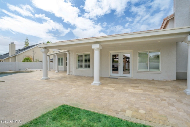 back of property with french doors, fence, a patio area, and stucco siding