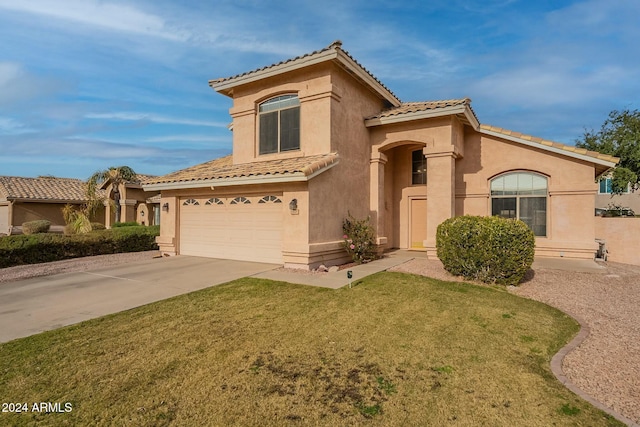 mediterranean / spanish home featuring a garage and a front lawn