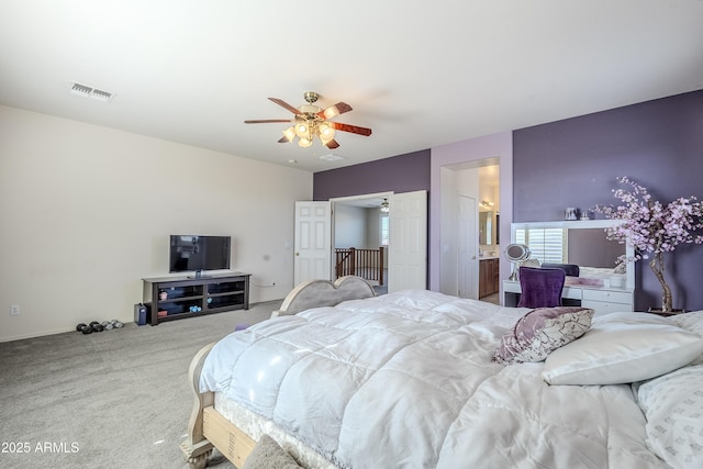 bedroom with ceiling fan, ensuite bathroom, and carpet floors