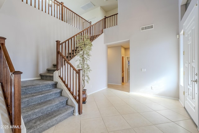 staircase featuring a high ceiling and tile patterned flooring