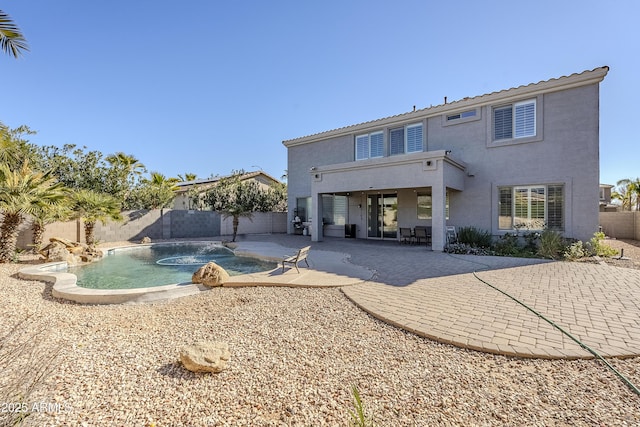 back of house with a fenced in pool, a patio area, and pool water feature