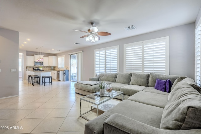 tiled living room with ceiling fan