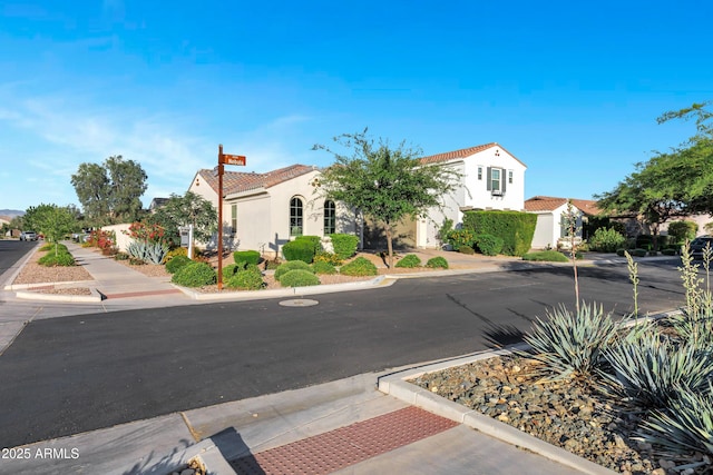 view of front of property with a residential view, a tiled roof, and stucco siding