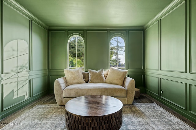 sitting room featuring a decorative wall, dark wood-type flooring, and crown molding
