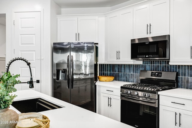 kitchen with stainless steel appliances, light countertops, decorative backsplash, and a sink