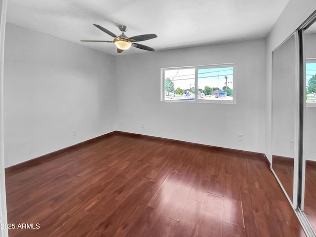 1750 E Mateo Cir Unit 103, Mesa, AZ 85204 - unfurnished bedroom featuring multiple windows, dark wood finished floors, a ceiling fan, and a closet