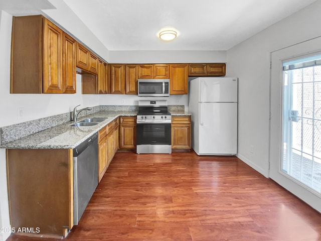 1750 E Mateo Cir Unit 103, Mesa, AZ 85204 - kitchen featuring appliances with stainless steel finishes, wood finished floors, light stone countertops, and brown cabinets